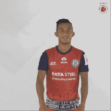 a man wearing a red shirt with tata steel on it