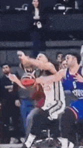 a basketball player with the number 6 on his jersey is being blocked by another player