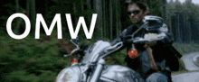 a man is riding a motorcycle on a road with the word omw written above him