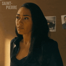 a woman is standing in front of a wall with saint pierre written on it