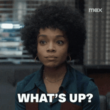 a woman with an afro says " what 's up " in front of a max logo