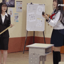 two girls are standing in front of a white board that says free on it