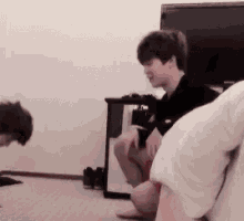 a couple of men are sitting on a bed in a room .