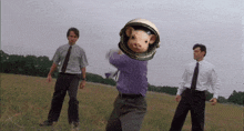 a man in a purple shirt has a pig in a space helmet on his head