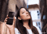 a woman is holding up a cell phone with appmart on the screen
