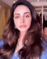 a close up of a woman 's face with a blue shirt on