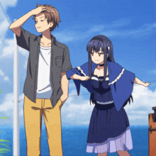 a man and a woman are standing next to each other in front of the ocean