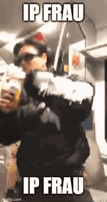 a man in a black jacket is holding a bottle of beer and says ip frau ip frau