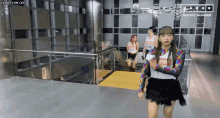 a woman is walking down a set of stairs in a building .