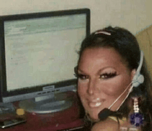 a woman wearing a headset sitting in front of a computer