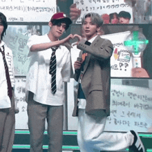 a man in a suit is making a heart with his hands