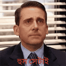 a man in a suit and tie is making a funny face in front of a window