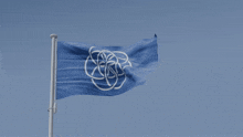 a blue flag with a white flower in the center