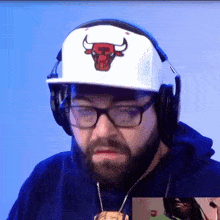 a man with a beard wearing headphones and a bull hat