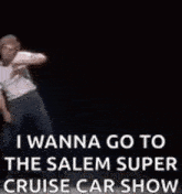 a man is dancing on a stage with the words `` i wanna go to the salem super cruise car show '' written on it .