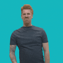 a man with red hair and a tattoo on his arm is making an angry face