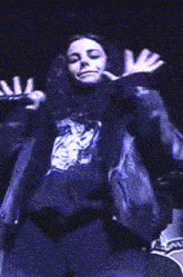 a woman with her arms outstretched is wearing a black jacket