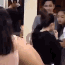a group of people are standing around a table in a room .