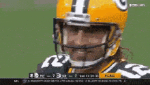 a green bay packers football player wearing a yellow helmet