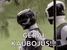 two power rangers are standing next to each other in a field and one of them is wearing a helmet .