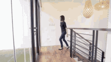 a woman is walking down the stairs in a house