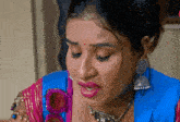 a close up of a woman wearing a blue top