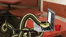 a snake is sticking its head into a laptop on a table