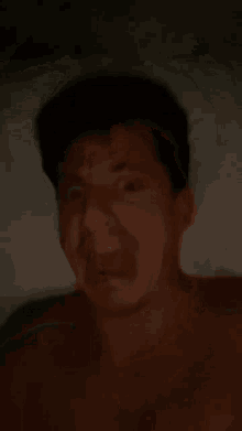 a shirtless man is making a funny face in the dark