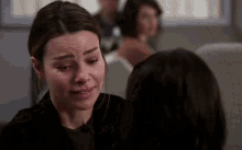 a woman is crying in front of another woman on a plane .