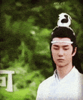 a man with a dragon on his head is wearing a white shirt and a white headband