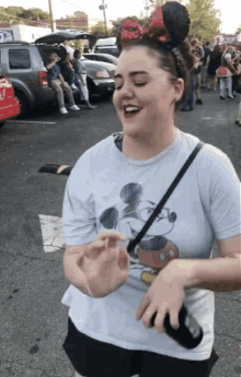 a woman wearing a minnie mouse ear headband and a mickey mouse t-shirt