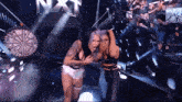 a couple of women standing on a stage with the word nxt behind them