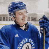 a hockey player wearing a blue jersey with the word hockey super on it