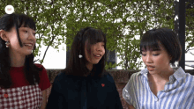 three girls are standing next to each other and one of them is wearing a shirt with a heart on it