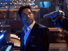 a man in a suit is holding a gun to his head in a dark room .