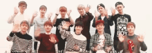 a group of young men are standing next to each other waving their hands in the air .