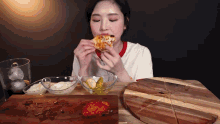 a woman is eating a slice of pizza on a wooden table