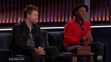 two men are sitting on a couch with the words songland written on the bottom