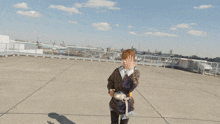 a person standing on a rooftop with their arm up
