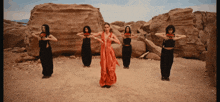 a woman in a red dress is surrounded by four other women