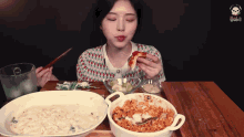 a woman is sitting at a table eating a pizza