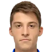 a young man wearing a blue shirt is looking at the camera