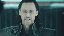 a close up of a man with long hair and glasses making a face .