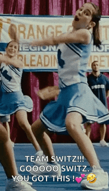 a cheerleader in a blue and white uniform says " team switz "