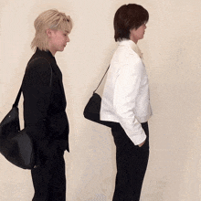 two men are standing next to each other and one has a black bag on his back