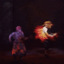 a man and a woman are dancing on a stage with fire projected on them