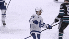 a hockey player wearing a maple leafs jersey is celebrating a goal