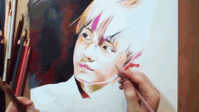 a person is holding a bunch of colored pencils in front of a drawing