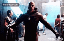 a man in a superhero costume is standing with his arms outstretched .