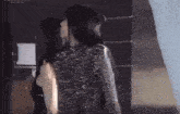 two women are standing next to each other and one is wearing a silver dress